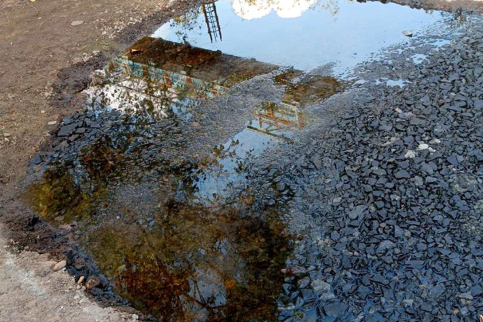 Before repair at NMPA — ponded water over a broken, sunken patch of pavement