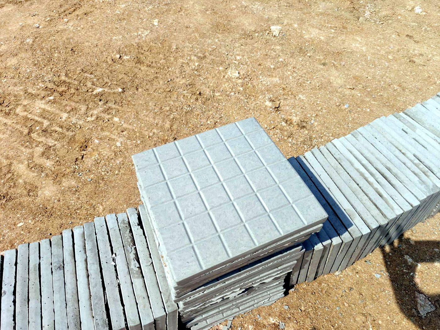 Chequered cement concrete tiles stacked after curing